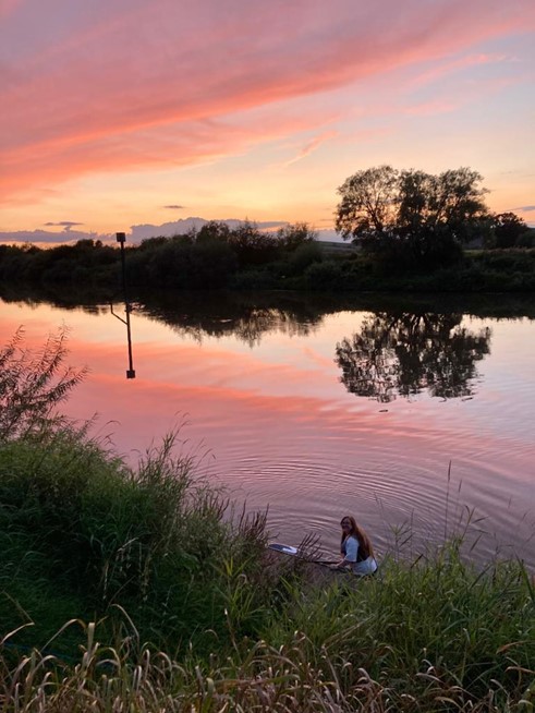 Lucy paddleboarding on a river