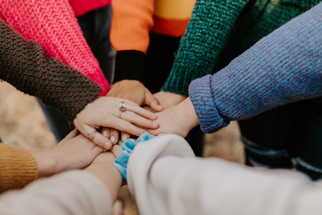 People placing their hands together as a symbol of community