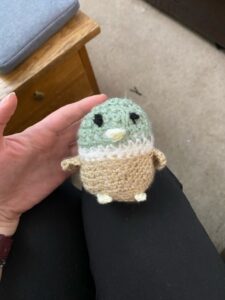 A photograph of a crochet duck